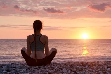 Sahilde meditasyon kadın. Günbatımı