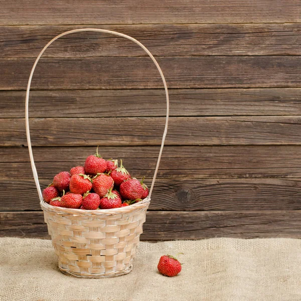 Cesta de fresas maduras sobre un saco. Espacio para texto — Foto de Stock