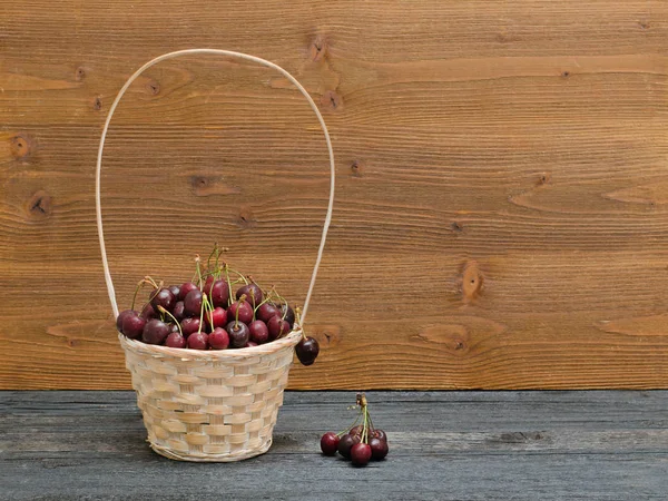 Kurv med kirsebær på et trebord. Kopirom – stockfoto
