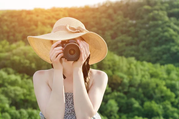 Dziewczyna w kapeluszu robi zdjęcia na tle zielonego lasu — Zdjęcie stockowe