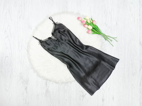 Black nightie on white fur. Pink tulips. Fashionable concept. — Stock Photo, Image