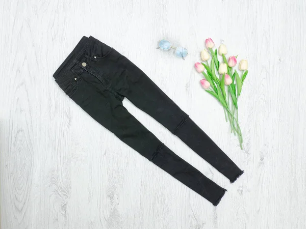 Zwarte jeans en boeket tulpen. Modieuze concept — Stockfoto
