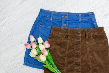 Moda kavramı. İki tane etek ve pembe laleler. 