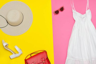 Beyaz sundress, kırmızı el çantası, beyaz ayakkabı ve güneş gözlüğü.