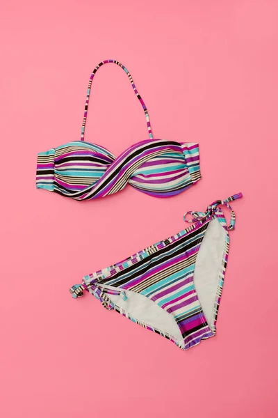 Strandkonzept. gestreifter Badeanzug. rosa Hintergrund — Stockfoto