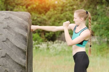 Genç kadın ile lastik boks. Egzersiz