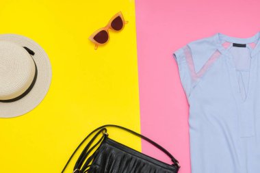 Kadın giysisi. Mavi top, el çantası ve şapka. Pembe ve sarı arka plan