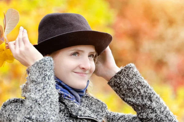 Menina em um chapéu com um buquê de folhas amarelas. Floresta de outono . — Fotografia de Stock