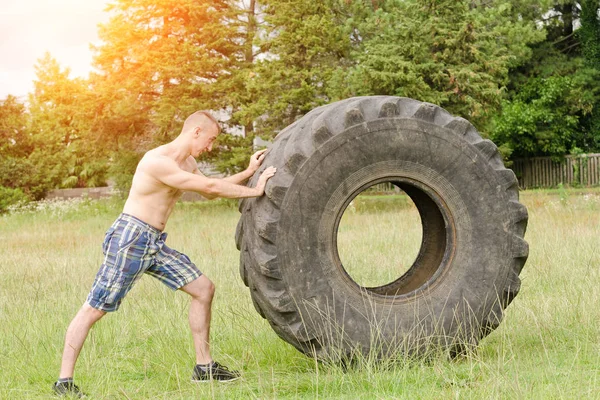 Man push a big tire. Street workout