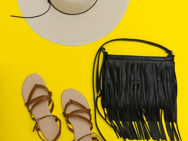 Conceito elegante. Chapéu de praia feminino, bolsa, sandálias. Fundo amarelo, vista superior — Fotografia de Stock