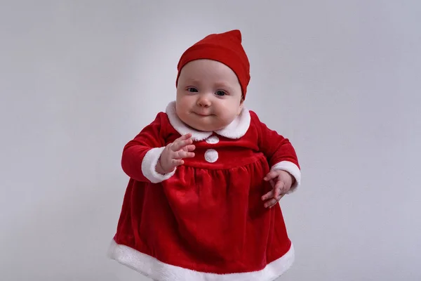 Dziecko w kostiumie Mikołaja jest zabawne. Białe tło. — Zdjęcie stockowe