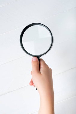 Beyaz arka planda bir çocuğun elinde büyüteç. Yakın plan.