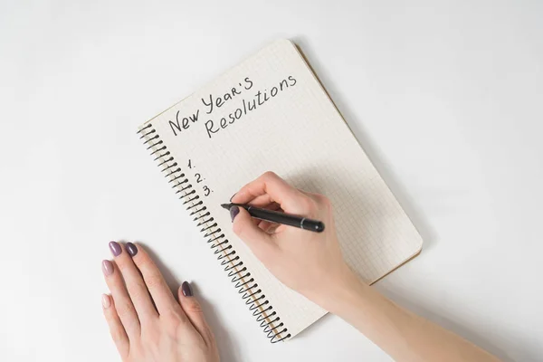 Zin in Oud en Nieuw resoluties in het notitieboekje. Vrouwelijke handen met pen — Stockfoto