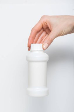 Kadın elinde beyaz plastik ilaç şişesi. Beyaz arkaplan