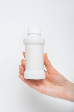 Kadın elinde beyaz plastik ilaç şişesi. Beyaz arkaplan