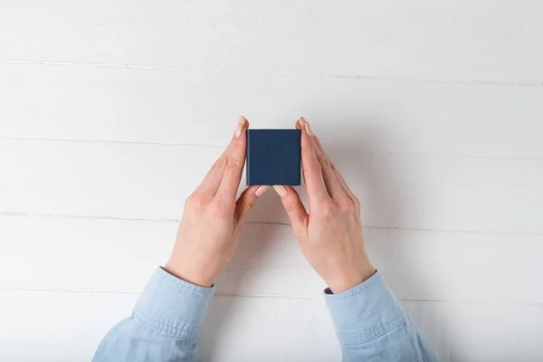 女性の手に小さな青い箱。存在する。白地 — ストック写真