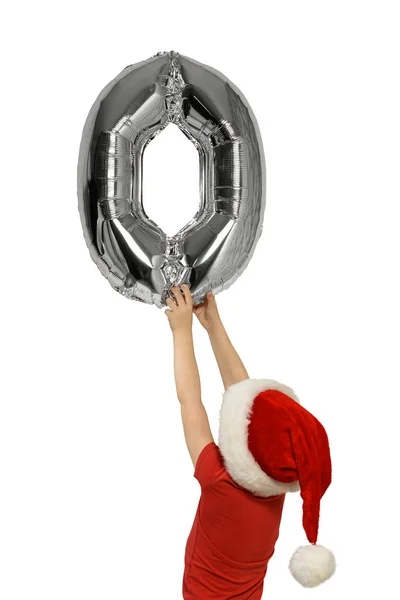 Niño en sombrero de Santa sostiene el dígito inflable de plata cero. Vista trasera. Aislado sobre fondo blanco — Foto de Stock