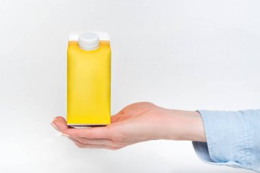 Sarı karton kutu ya da elinde kadın eli olan tetra paketi. Beyaz arkaplan