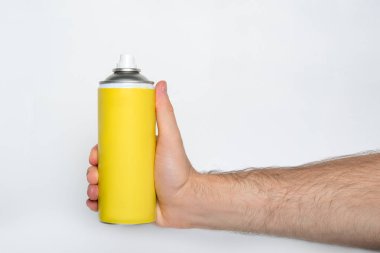 Erkek eline sprey sıkmak için sarı sprey. Yazıt yok. Beyaz arkaplan