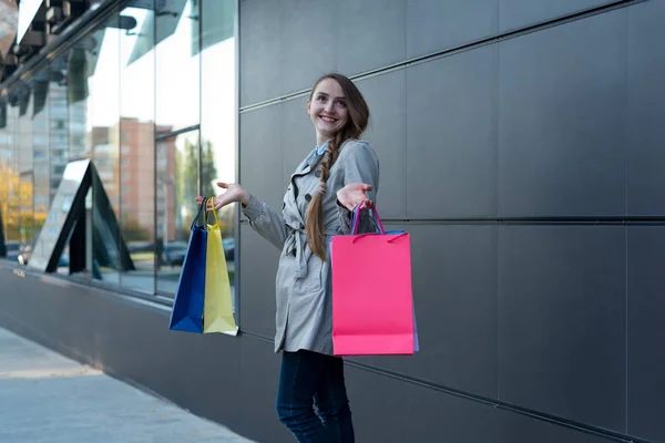Šťastná mladá žena shopaholic s barevnými taškami v blízkosti obchoďáku. Procházka po ulici. — Stock fotografie