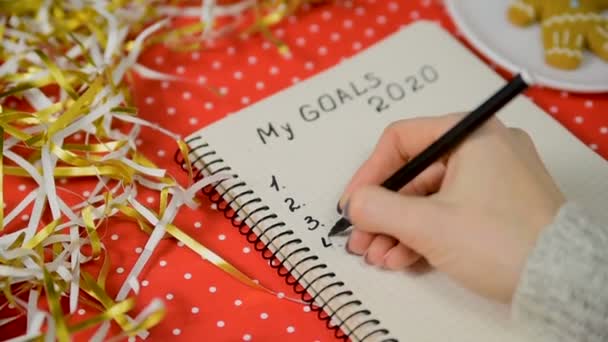 Manos Femeninas Escribiendo Goles 2020 Cuaderno Fondo Rojo Oropel Concepto — Vídeos de Stock