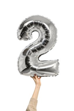 Kadın elinde gümüşi şişirilebilir figür iki. Yakın plan. Beyaz arkaplanda izole et