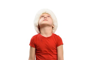 Blond boy in Santa hat is looking up. Isolate
