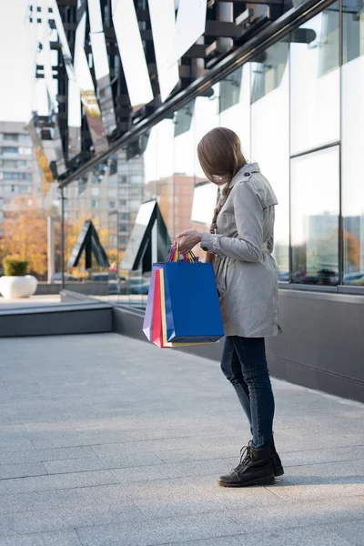 Mujer joven con bolsas de colores cerca del centro comercial. Shopaholic —  Fotos de Stock