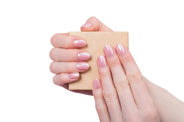 Malá kartónová krabička v ženských rukou. Jemná růžová manikúra. Bílé pozadí, izolovat — Stock fotografie