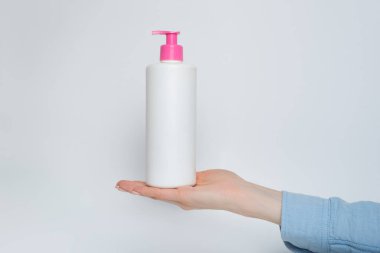 Kadın eli pompalı beyaz kozmetik plastik şişe. Beyaz arkaplan