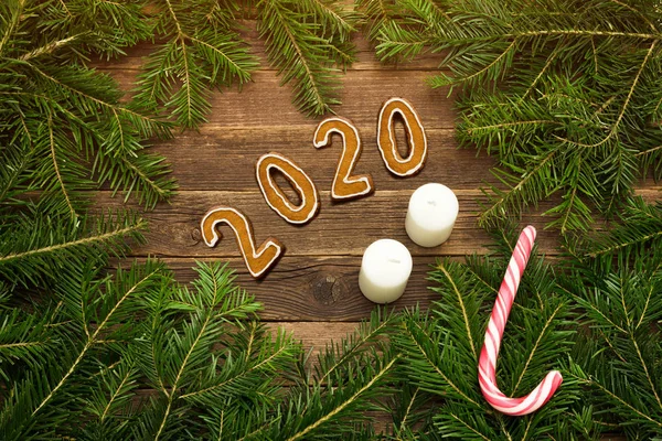 Número 2020 de galletas de jengibre. Fondo de madera. Ramas de abeto, dulces y velas. Concepto de Navidad . — Foto de Stock