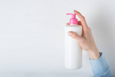 Kadın eli pompalı beyaz kozmetik plastik şişe. Beyaz arkaplan