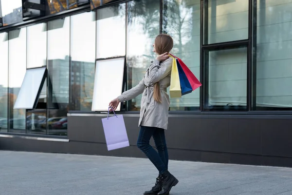 Šťastná mladá žena shopaholic s barevnými taškami v blízkosti obchoďáku. Procházka po ulici. — Stock fotografie