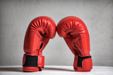 Beyaz arka planda bir çift kırmızı boks eldiveni. Yakın plan.