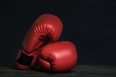 Siyah arka planda bir çift kırmızı boks eldiveni. Boşluğu kopyala