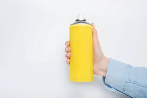 Lata de spray amarillo para rociar en una mano femenina. No hay inscripciones. Fondo blanco —  Fotos de Stock