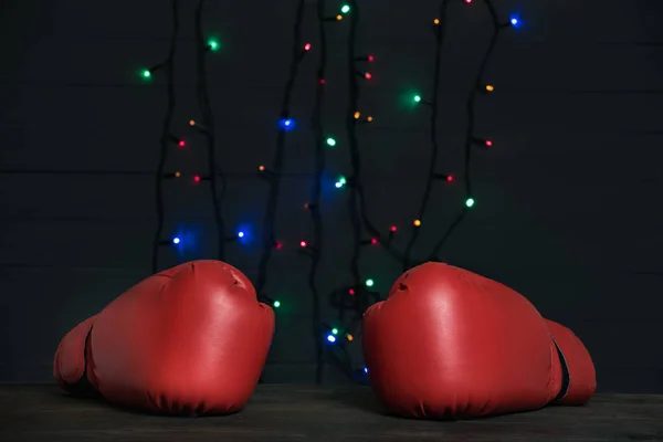 Para czerwonych rękawic bokserskich, świąteczna girlanda na tle. Dzień boksu — Zdjęcie stockowe