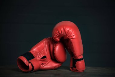 Siyah arka planda bir çift kırmızı boks eldiveni. Boşluğu kopyala