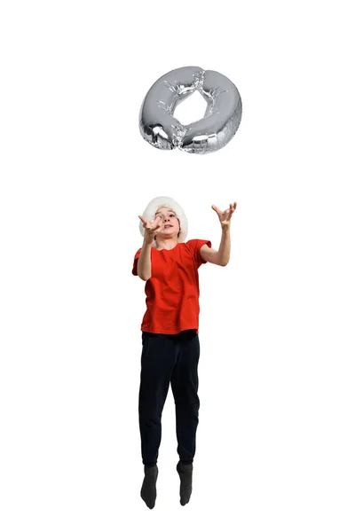 Niño en el sombrero de Santa lanza un plateado inflable 0. Fondo blanco. Concepto de Año Nuevo — Foto de Stock