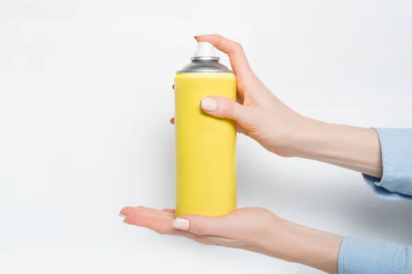 Lata de spray amarillo para rociar en manos femeninas. No hay inscripciones. Fondo blanco —  Fotos de Stock