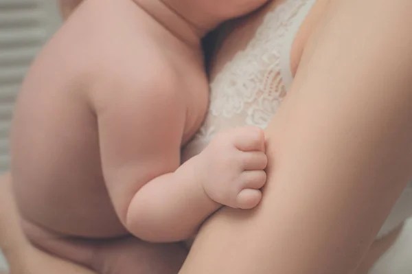 Barnens hand närbild. Mor med ett barn i famnen. Moment av ömhet. — Stockfoto