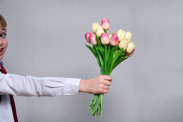 Boeket tulpen in de hand van een kind. Witte achtergrond. Close-up — Stockfoto