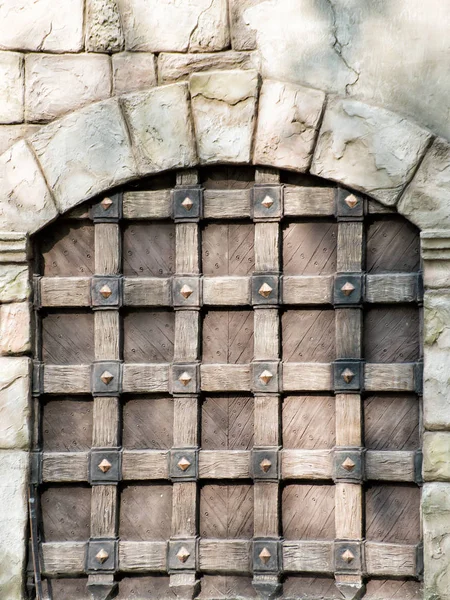 Огромные деревянные ворота с аркой в стене из больших камней — стоковое фото