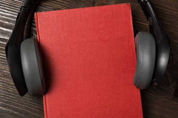 Słuchawki i książki na drewnianym stole. Posłuchaj książki, koncepcja audiobooka. — Zdjęcie stockowe