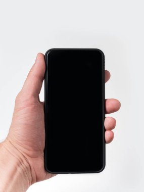 Beyaz arka planda erkek eli cep telefonu. İzole edilmiş, boşluğu sözel olarak kopyala