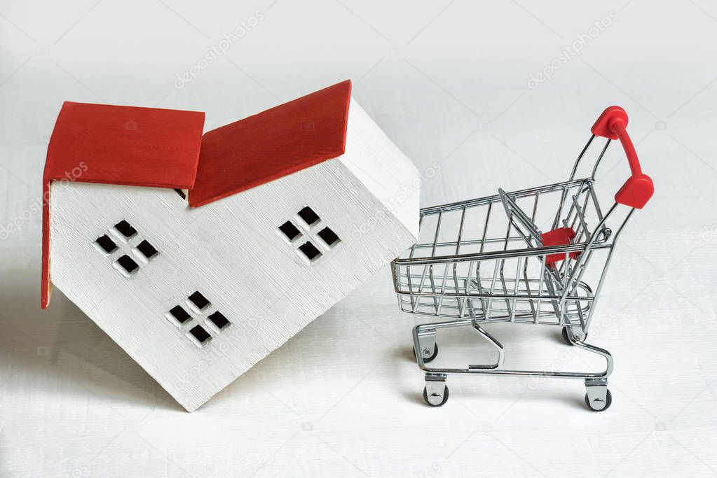 Model of house and basket on white background. Buying a house. Real estate and mortgage concept.