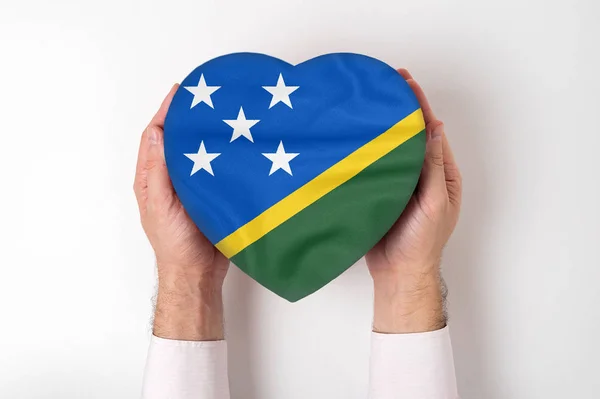 Bandera de las Islas Salomón en una caja en forma de corazón en manos masculinas. Fondo blanco — Foto de Stock
