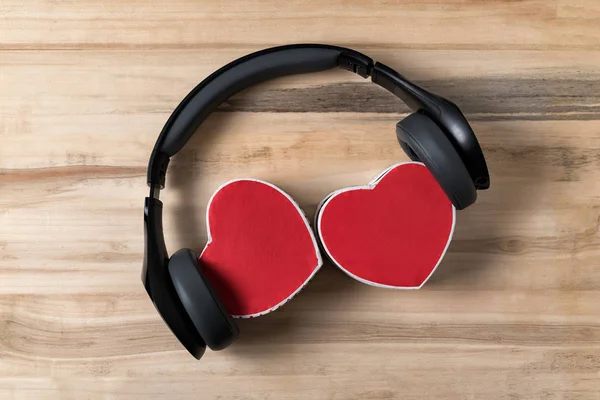 Wireless headphones and two heart shaped boxes on wooden background. Music of hearts. Directly above. — Stock Photo, Image