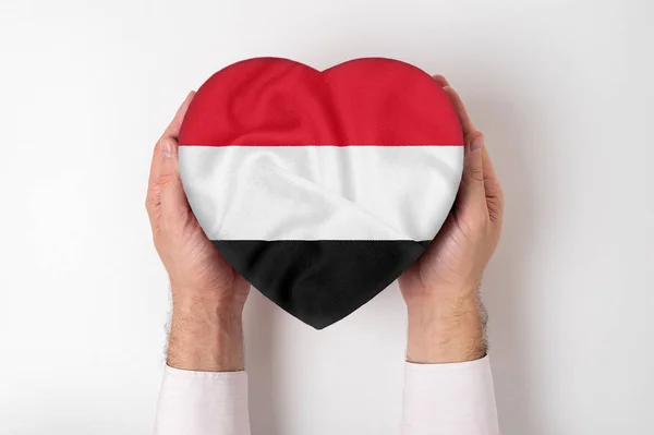 Bandera de Yemen en una caja en forma de corazón en manos masculinas. Fondo blanco — Foto de Stock