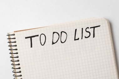 Yapılacaklar listesi için el yazısı uyarısı. Not defteri beyaz arkaplanda. Üst görünüm